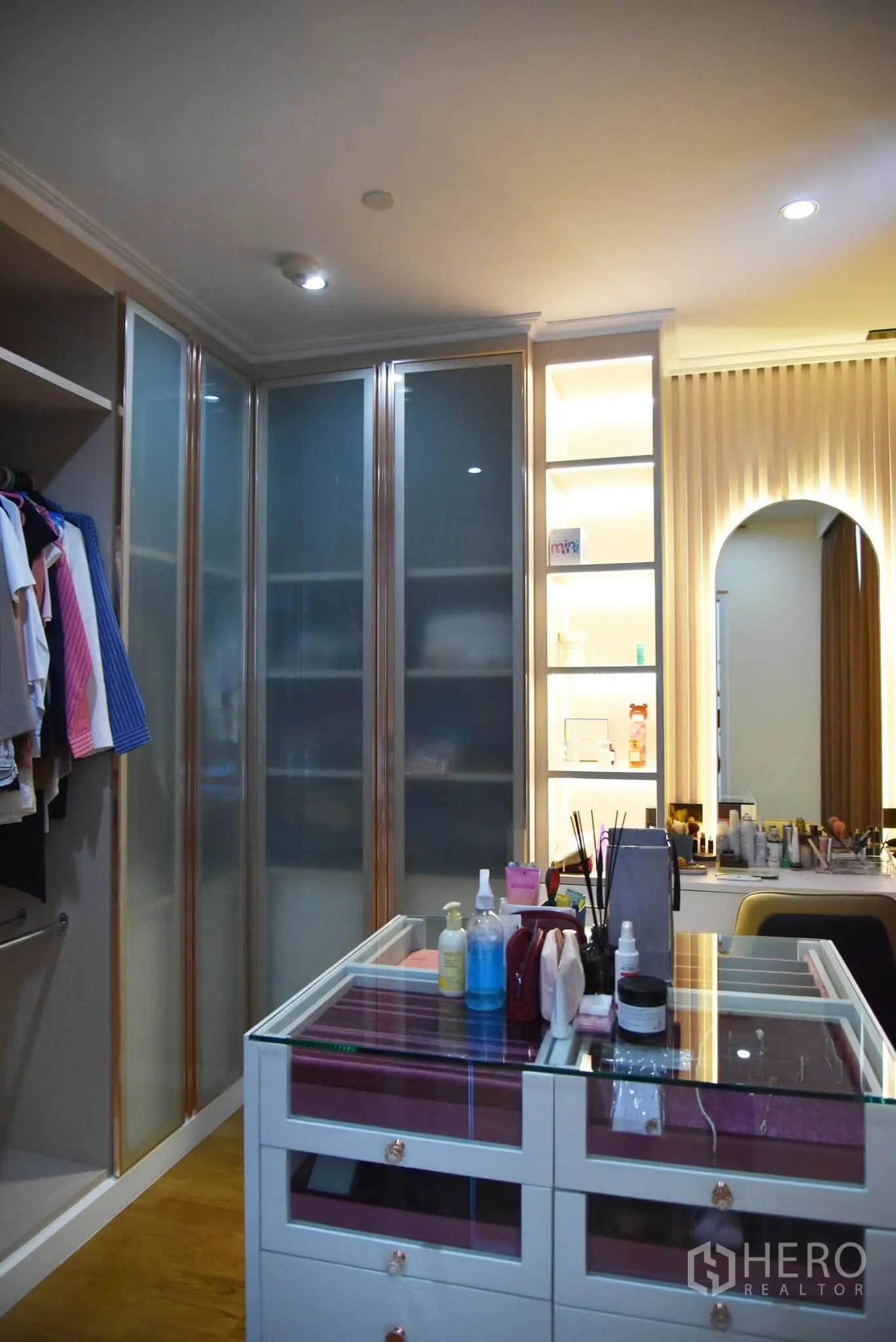 Condominium for sale in Khlong San, Bangkok - Walk-in closet with glass-top island, makeup station, and illuminated shelving.