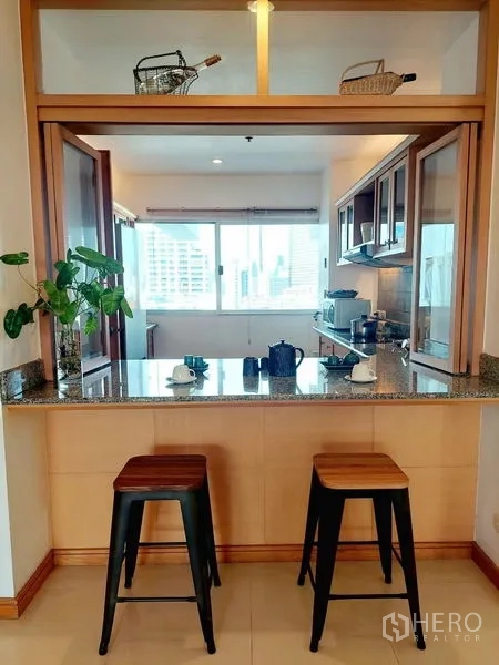อพาร์ทเมนท์ ให้เช่า - บาร์ท็อปหินแกรนิตพร้อมสตูลสองตัว มองเข้าครัวแบบปิด