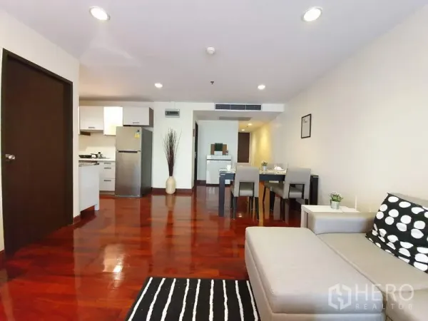 Condominium for rent or sale in Pathum Wan, Bangkok - Open-plan living, dining and compact kitchen with stainless fridge and hardwood floors.