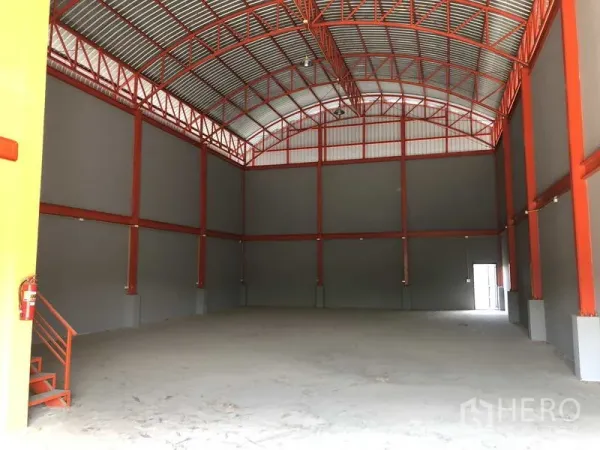 货栈 出租在Nonthaburi - 无柱仓储大厅，墙体高挑，屋脊采光，平整的混凝土地面。