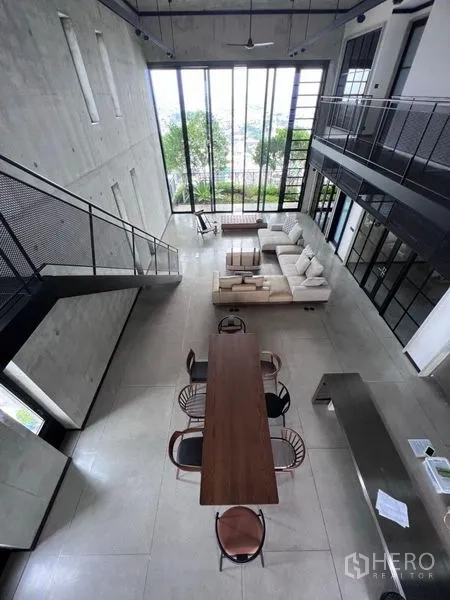 คอนโด ให้เช่าในSathon, Bangkok - มุมมองมุมสูงของโต๊ะกินข้าว ห้องนั่งเล่น และบันไดสไตล์อินดัสเทรียลในพื้นที่เพดานสูง