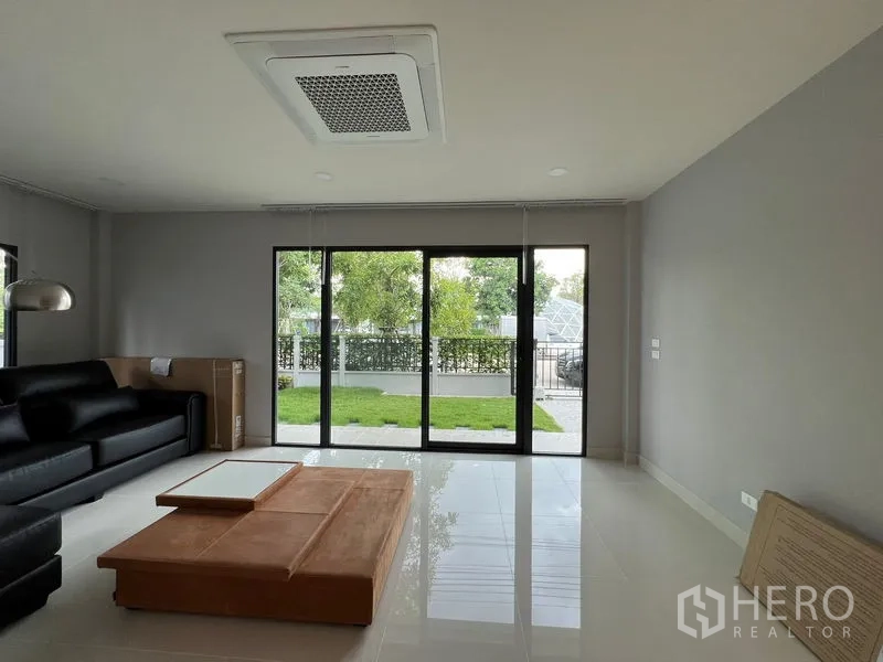 Detached House for rent or sale in Bang Phli, Samut Prakan - Living room view to sliding glass doors opening to a private yard.