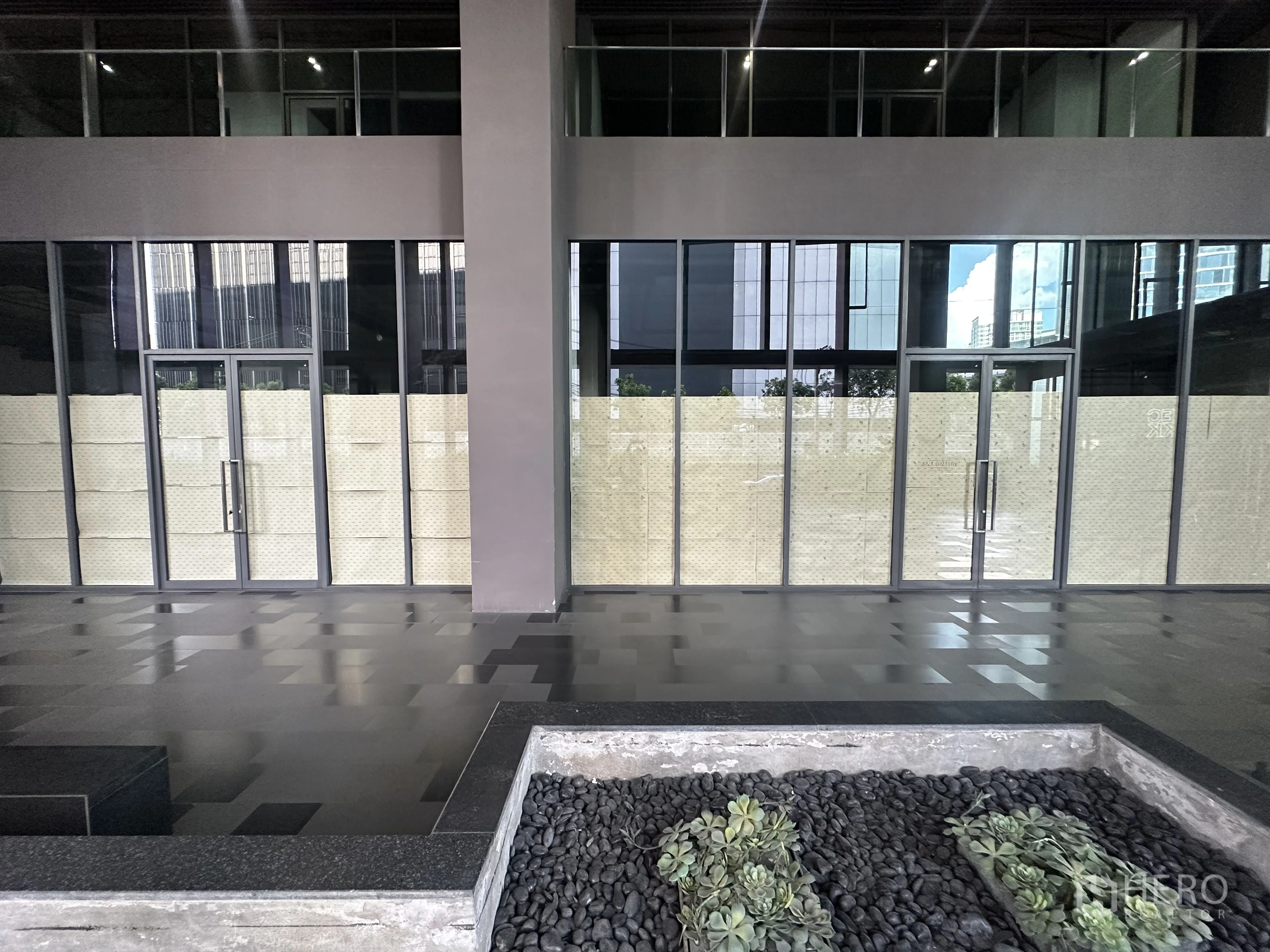 Retail Space for rent in Khlong Toei, Bangkok - Modern retail frontage with floor-to-ceiling glass, double doors, and planter beds.