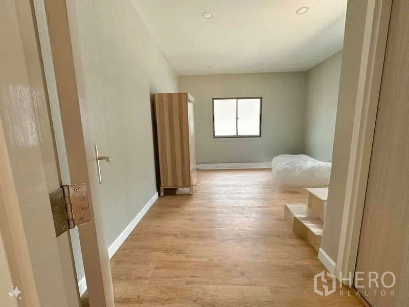 บ้าน ขายในLat Krabang, Bangkok - ห้องนอนเรียบง่าย มีตู้เสื้อผ้า หน้าต่าง และพื้นไม้