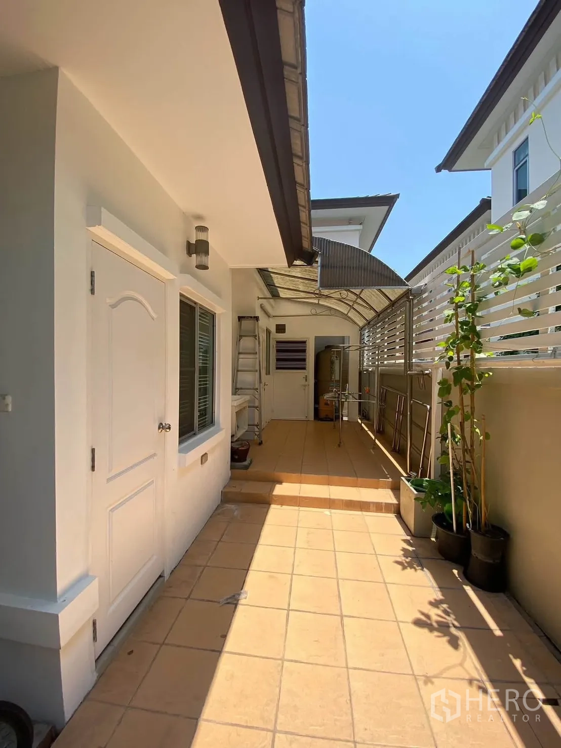 Detached House for rent in Mueang Samut Prakan, Samut Prakan - Long tiled service corridor with canopy roof and drying racks.