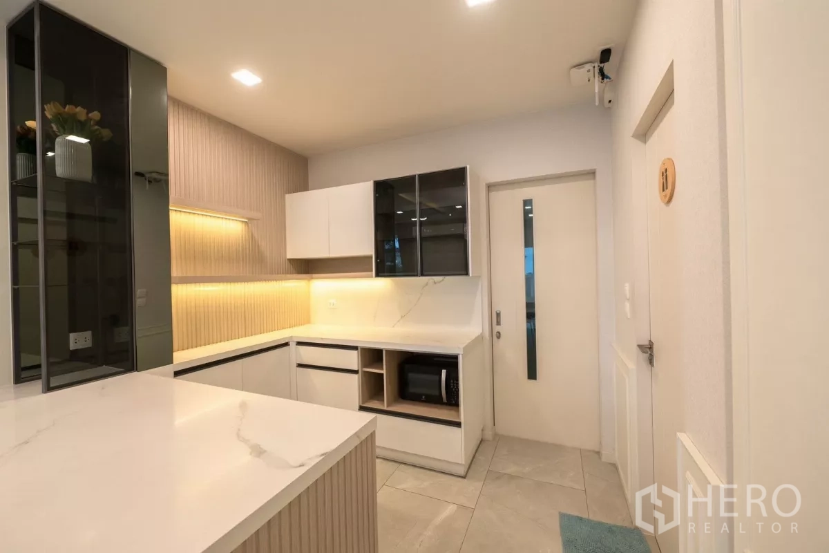 Detached House for rent or sale in Prawet, Bangkok - Built-in pantry with marble-look counters and illuminated display cabinets.