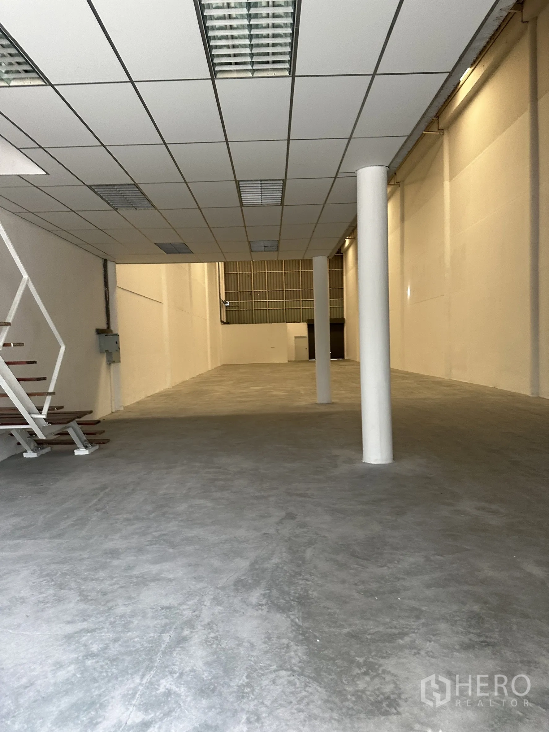 工厂 出租在Khlong Luang, Pathum Thani - 夹层下方地面空间，吊顶灯具与光洁混凝土地坪。