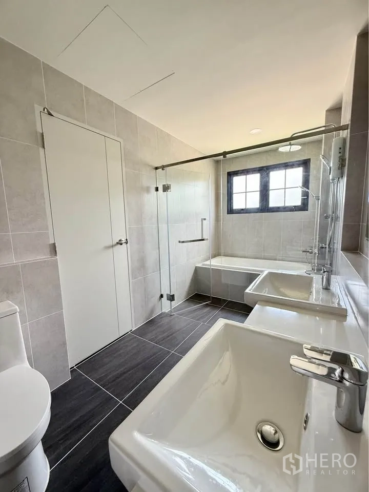 Detached House for rent in Bang Phli, Samut Prakan - Modern bathroom with double sinks, glass shower, bathtub, and toilet.