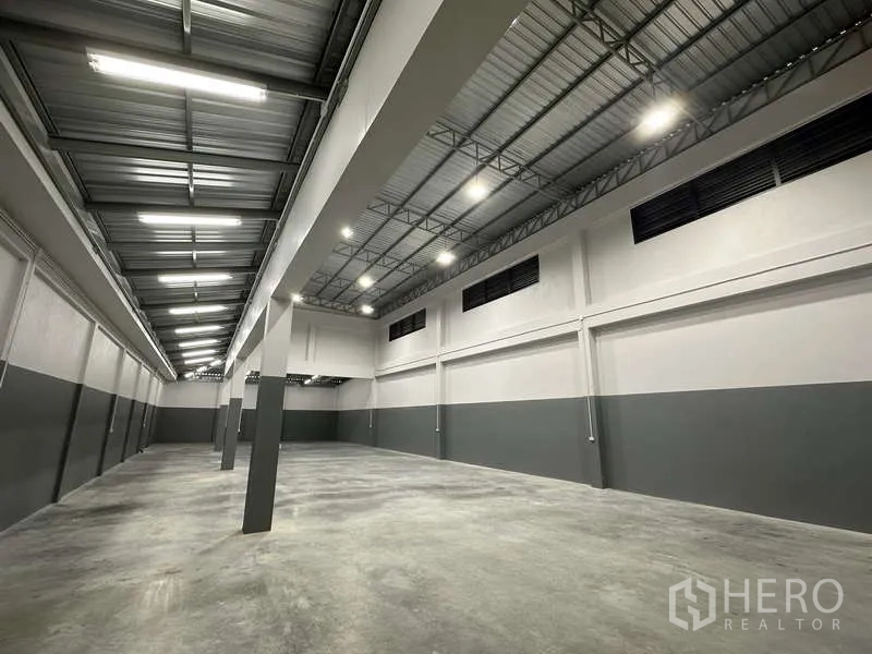 工厂 出租或出售在Bang Bua Thong, Nonthaburi - 高挑仓库内部，钢桁架屋顶与抛光地坪。
