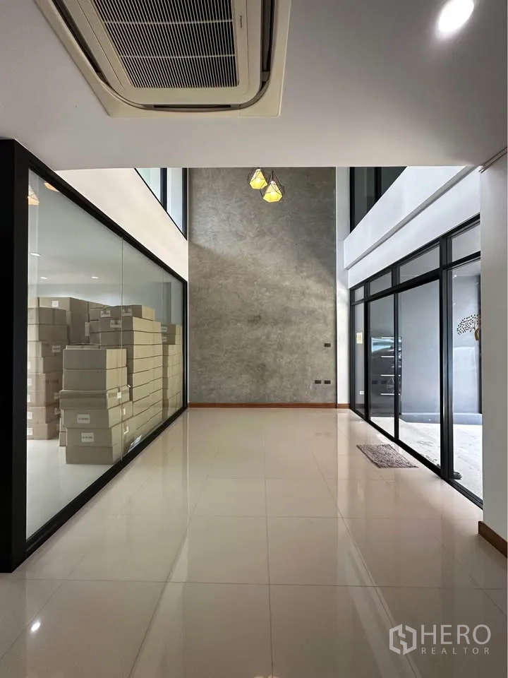 Townhouse for rent in Pak Kret, Nonthaburi - Bright double-height entrance hall with glossy tile floors, glass partitions, and cassette AC.