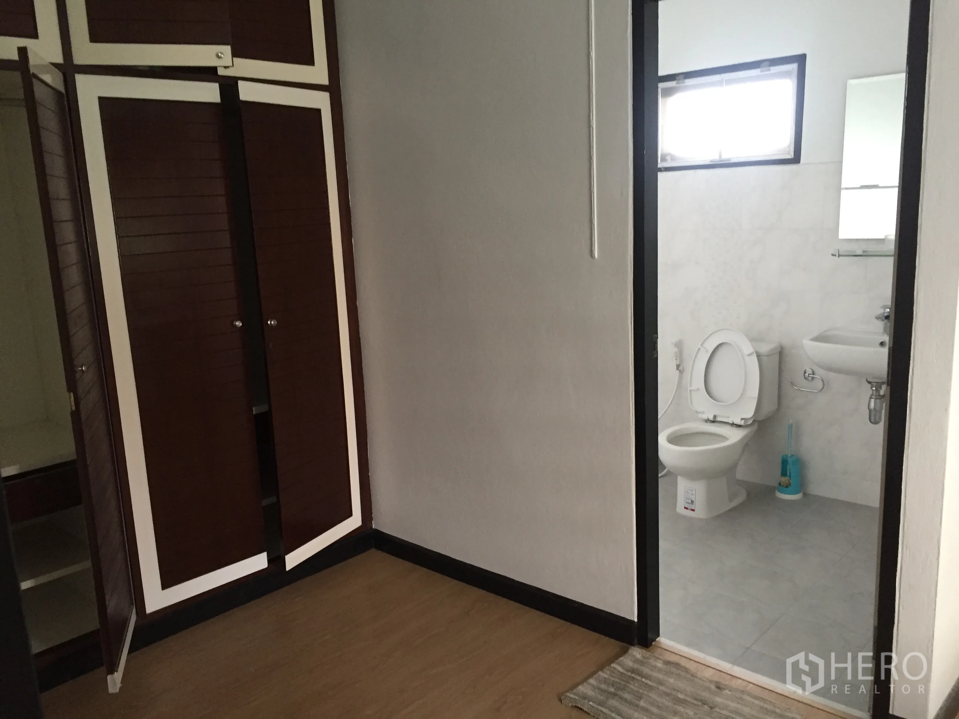 Townhouse for rent in Khlong Toei, Bangkok - Bedroom corridor with closets leading to a bright bathroom.