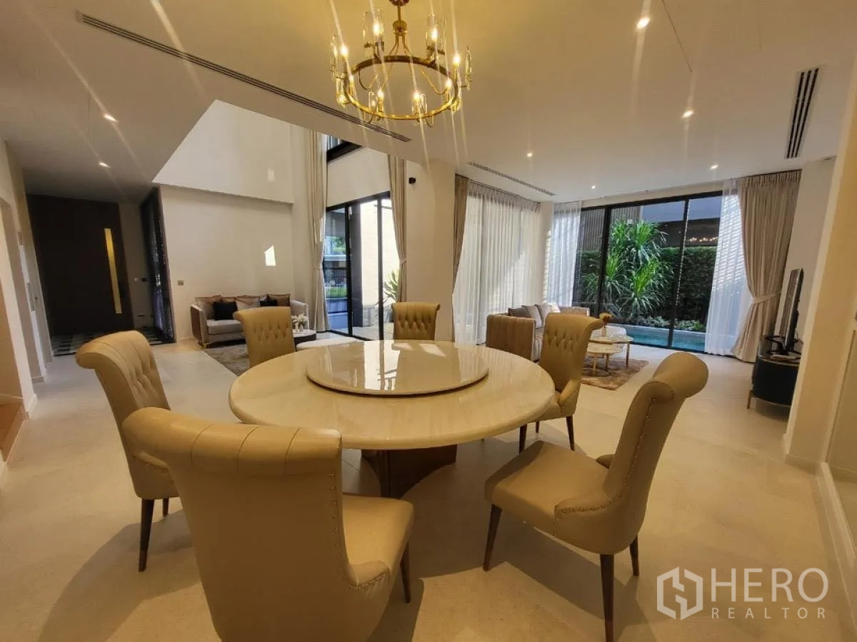 บ้าน ให้เช่าในWang Thonglang, Bangkok - โซนรับประทานอาหารหรู โคมแชนเดอเลียร์และโต๊ะกลม มองเห็นสระและสวน