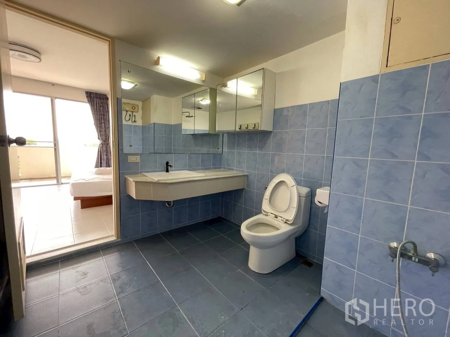 Condominium for sale in Wang Thonglang, Bangkok - Blue-tiled bathroom attached to bedroom with balcony access.