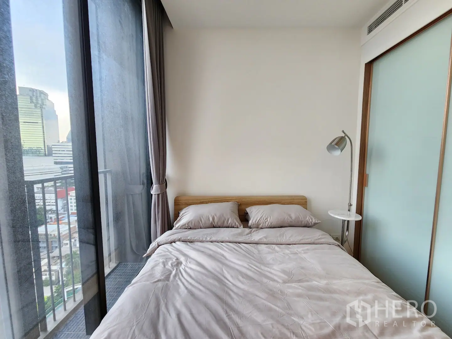 คอนโด for rent in Watthana, Bangkok - ห้องนอนเล็กเตียงชิดหน้าต่างสูงติดระเบียง พร้อมโคมไฟอ่านหนังสือ มองเห็นสกายไลน์เมือง