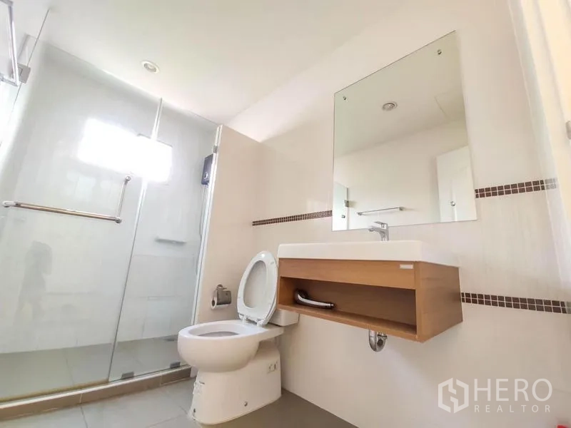 Detached House for rent - Clean bathroom with glass shower enclosure, wall-mounted vanity and toilet