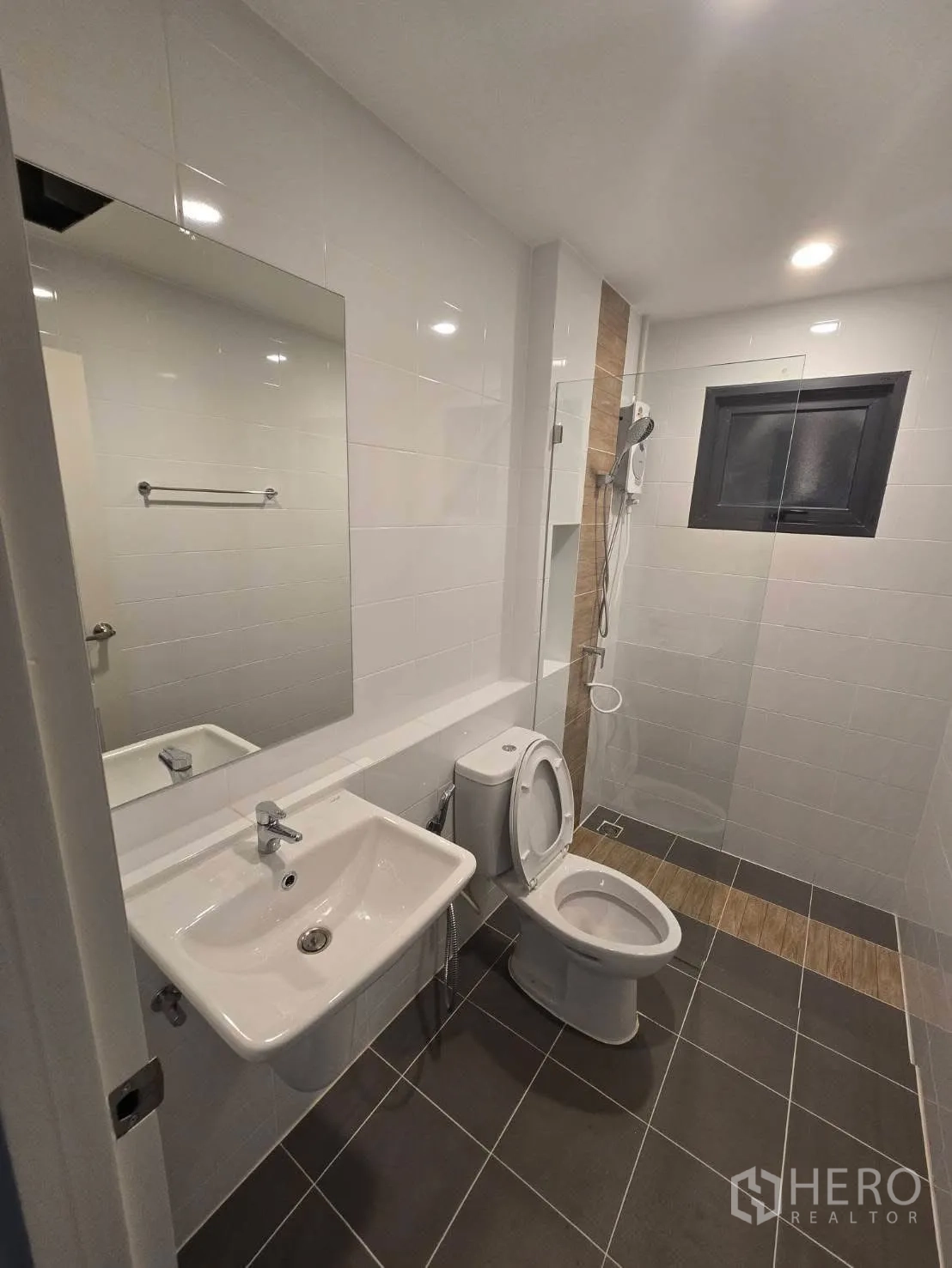 Semi-detached House for rent in Bang Phli, Samut Prakan - Clean bathroom with toilet, basin, mirror, and separate shower area.