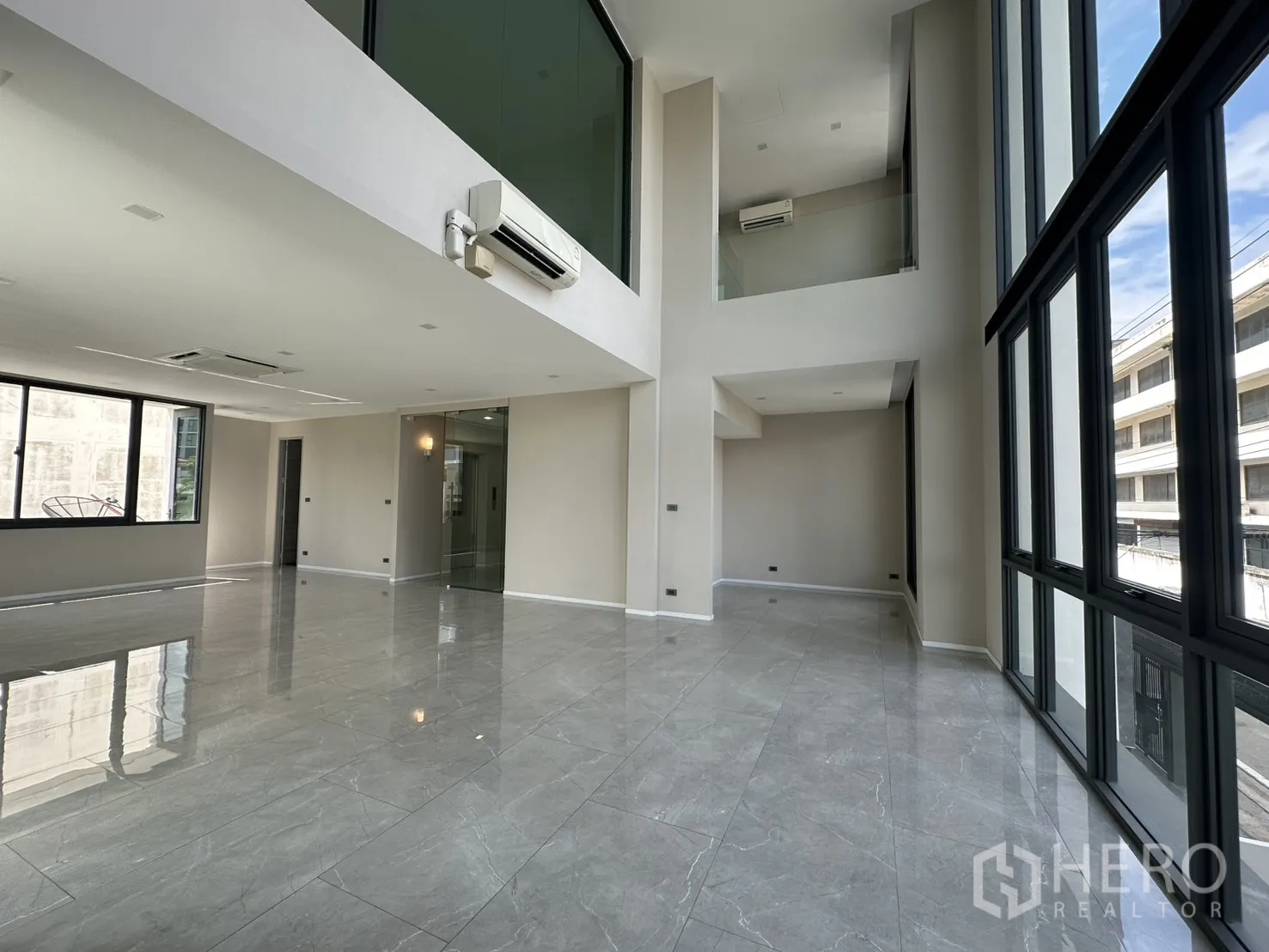 Home Office for rent or sale in Suan Luang, Bangkok - Spacious double-height office space with glass partitions and AC.