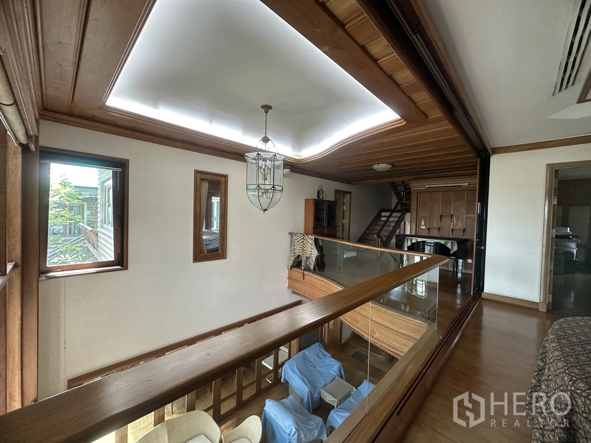 Detached House for rent in Lam Luk Ka, Pathum Thani - Mezzanine walkway with glass railing overlooking the living room below.