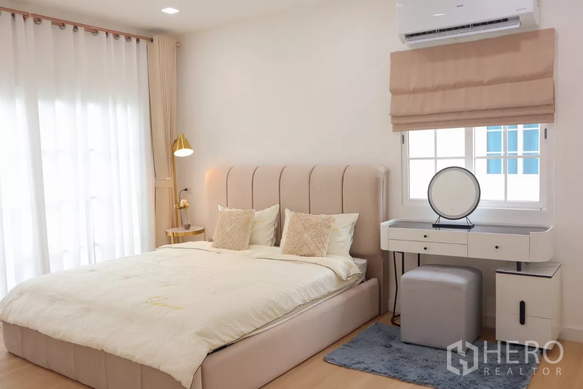 Detached House for rent in Bang Phli, Samut Prakan - Primary bedroom with upholstered bed, bedside lamp and dressing table.