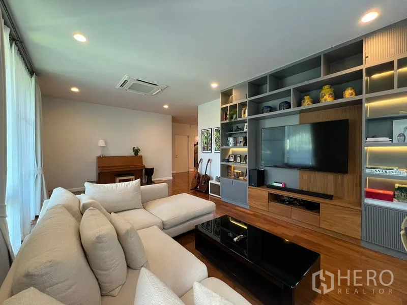 Detached House for rent in Bang Kapi, Bangkok - Living room media wall with TV and illuminated shelving units.