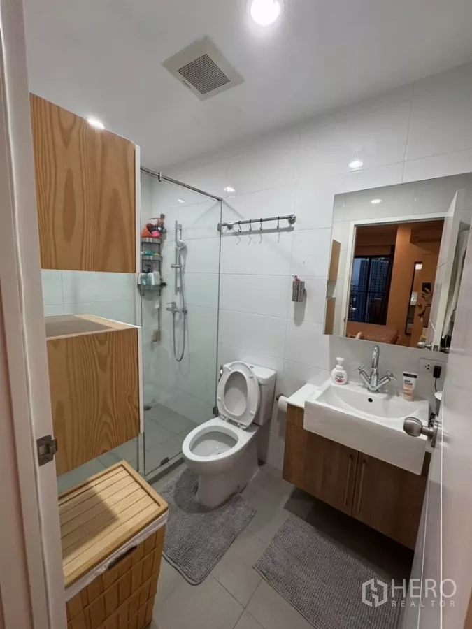Condominium for rent in Watthana, Bangkok - Contemporary bathroom with glass-enclosed shower, vanity and toilet.