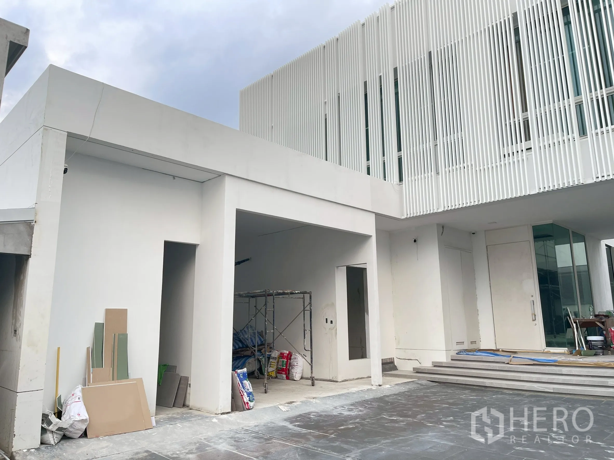 Detached House for sale in Bang Phli, Samut Prakan - Close-up of driveway, carport bays and vertical screened upper floor.