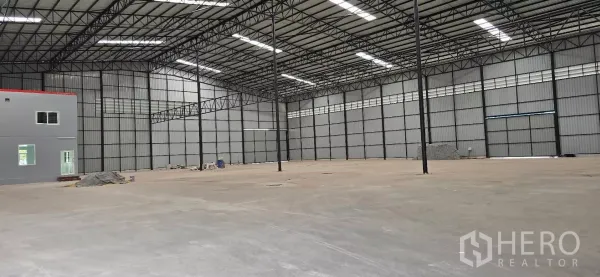 工厂 出租在Mueang Samut Sakhon, Samut Sakhon - 厂房内部，高挑钢桁架屋顶、天窗与抛光混凝土地面。