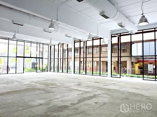 Office Space for rent in Watthana, Bangkok - Open-plan office floor with exposed ducting and wraparound glass walls bringing natural light.