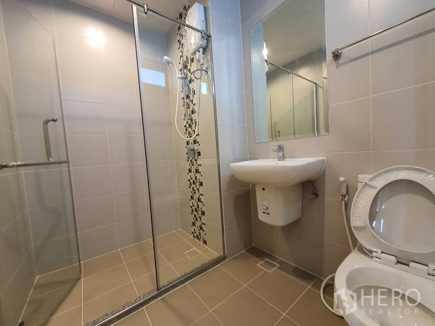 คอนโด for rent in Huai Khwang, Bangkok - ห้องน้ำสมัยใหม่ มีกระจกกั้นอาบน้ำ อ่างล้างหน้า และโถสุขภัณฑ์ ผนังโทนเรียบ