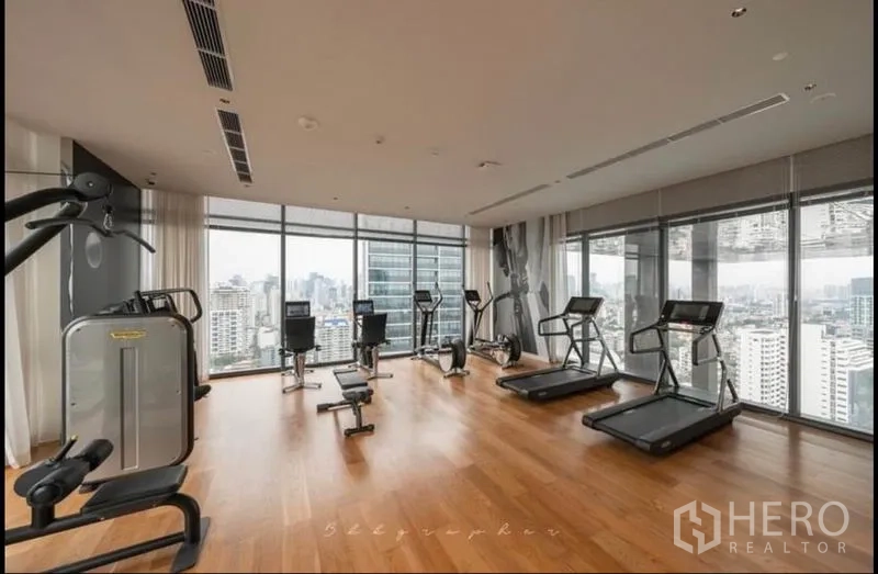 公寓 出租或出售在Watthana, Bangkok - 高层健身房，跑步机与器械面向城市景观。