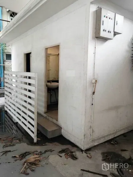 พื้นที่ขายปลีก ให้เช่าในKhlong Toei, Bangkok - อาคารห้องน้ำภายนอกพร้อมอ่างล้างหน้าและตู้ควบคุมไฟ