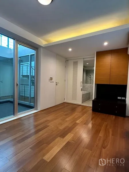 Townhouse for sale in Yan Nawa, Bangkok - Bedroom with built-in cabinetry, wood floors and door to marble bathroom and terrace