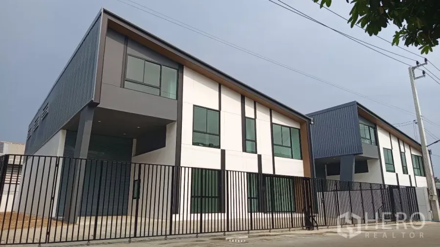 货栈 出租或出售在Lam Luk Ka, Pathum Thani - 全新现代风仓库，斜屋顶与大窗，前方黑色金属围栏，位于Lam Luk Ka。