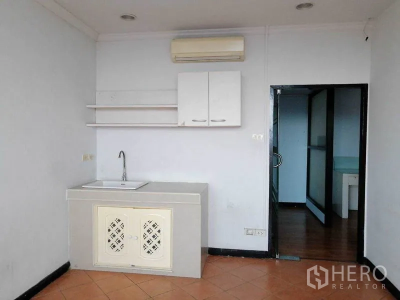 Office Space for rent in Bueng Kum, Bangkok - Compact pantry with sink, wall cabinets, shelves, and air conditioning.