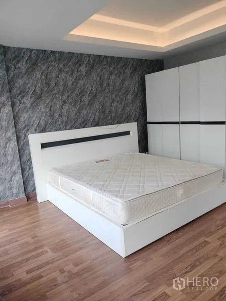 ทาวน์เฮาส์ ให้เช่าในBueng Kum, Bangkok - ห้องนอนเตียงแพลตฟอร์มสีขาว ตู้เสื้อผ้า พื้นไม้ และผนังลายหิน