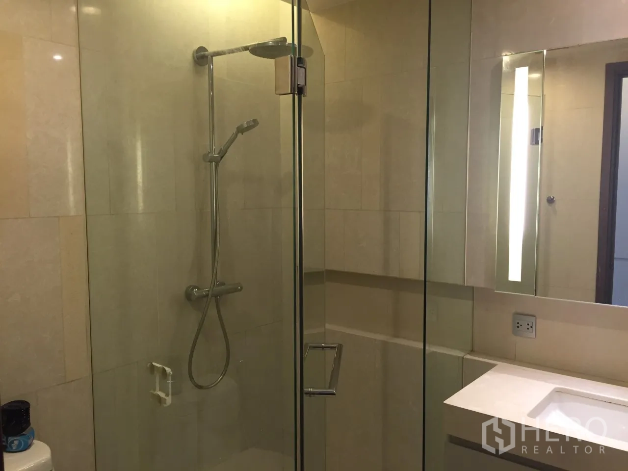 Condominium for rent or sale in Watthana, Bangkok - Glass-enclosed shower with handheld spray and illuminated mirror vanity.