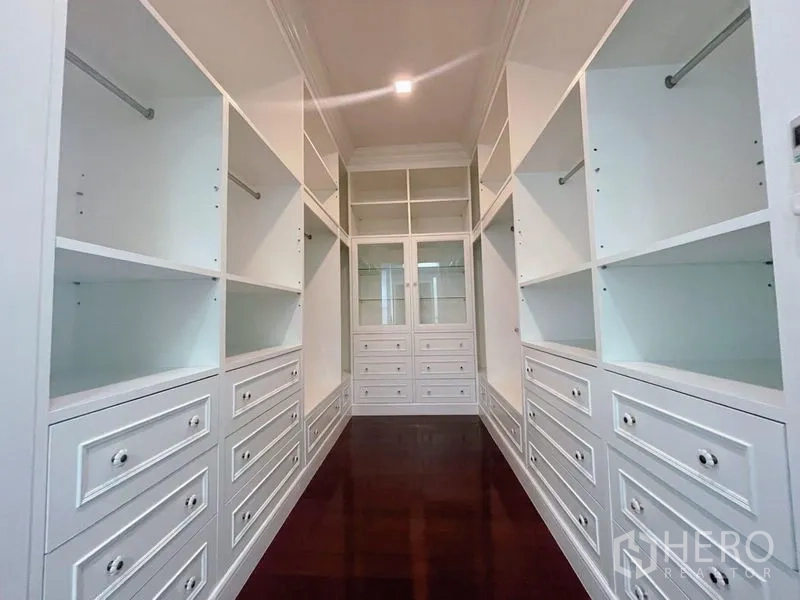 Detached House for rent or sale in Bang Phli, Samut Prakan - Spacious walk‑in closet with white built‑in cabinetry, drawers, and shelving on both sides.