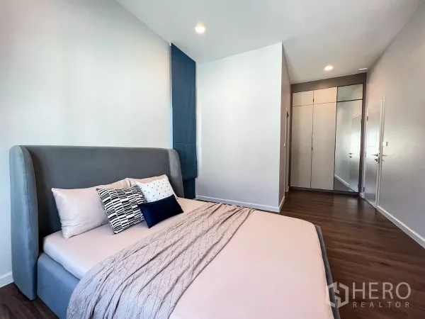 บ้าน ให้เช่าในKhan Na Yao, Bangkok - ห้องนอนอบอุ่น เตียงกำมะหยี่สีเทา พื้นไม้ และตู้เสื้อผ้าบิวท์อิน