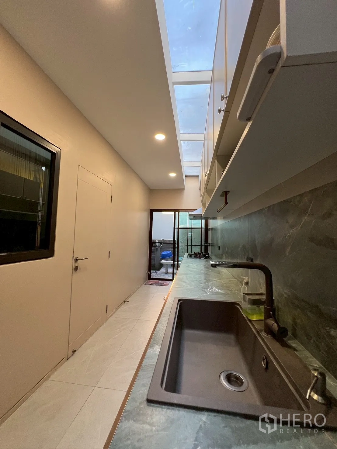 独栋房屋 for rent in Bang Kapi, Bangkok - 服务厨房，长操作台、水槽与天窗顶。