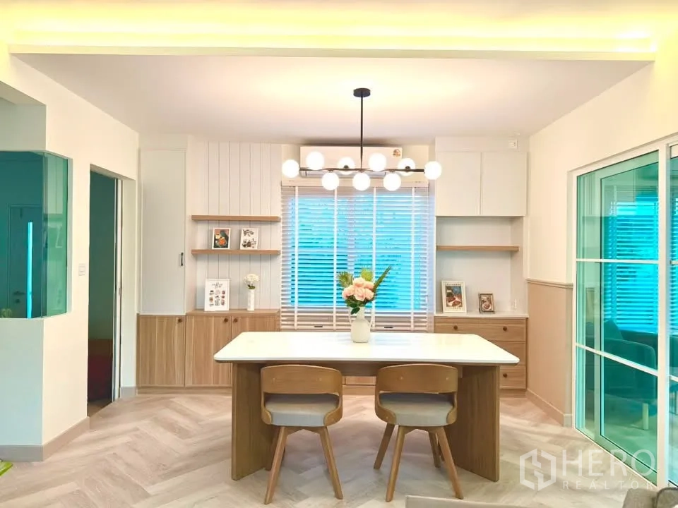 独栋房屋 for rent in Bang Phli, Samut Prakan - 餐区配现代吊灯、中岛式餐桌与储物柜。