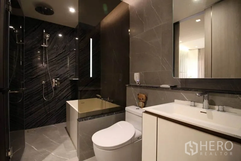 Condominium for rent in Watthana, Bangkok - Modern bathroom with rain shower, separate bathtub, vanity and gray marble-style tiles.