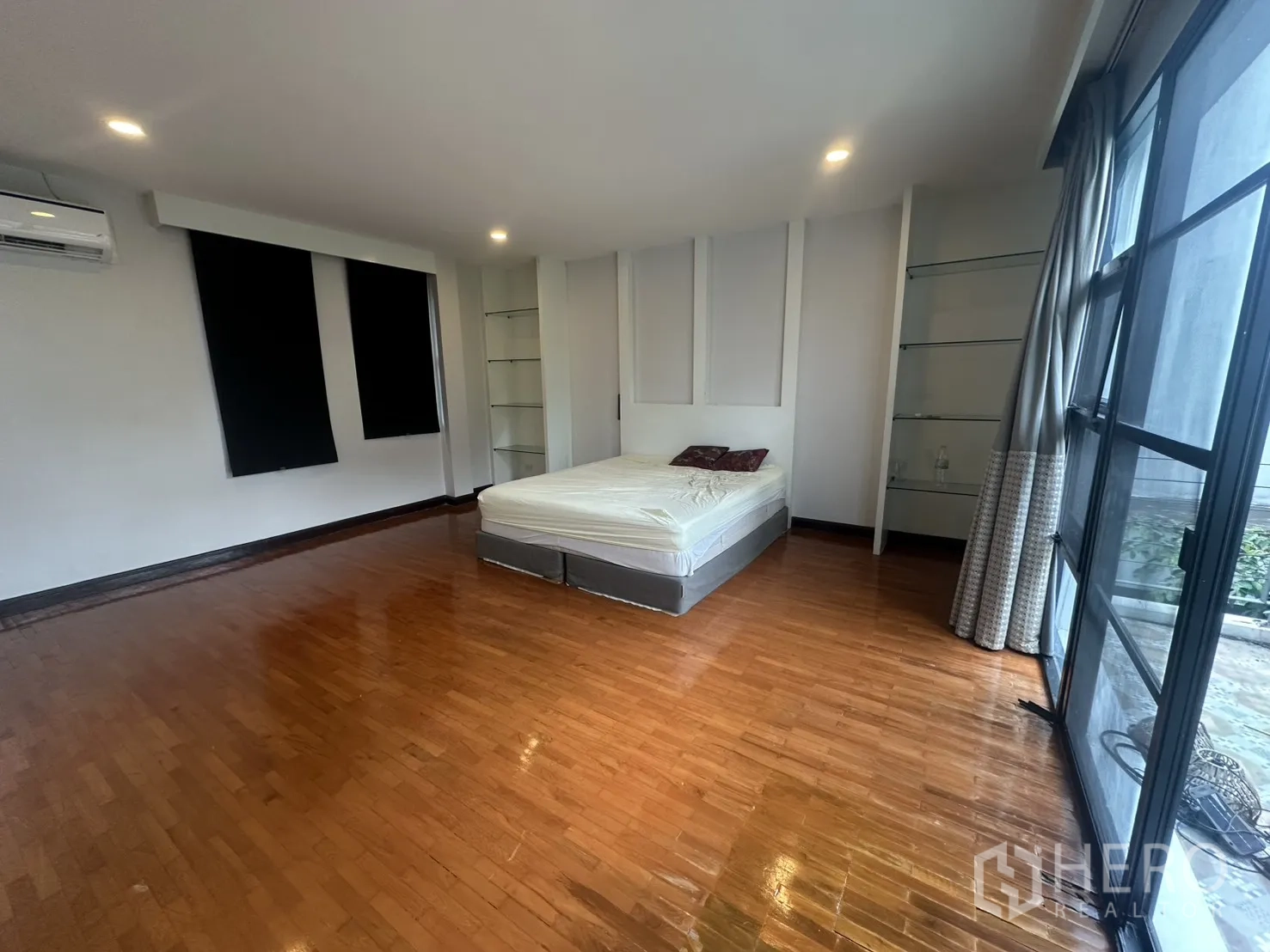 独栋房屋 for rent in Watthana, Bangkok - 宽敞卧室，木地板、床、空调与内置搁架