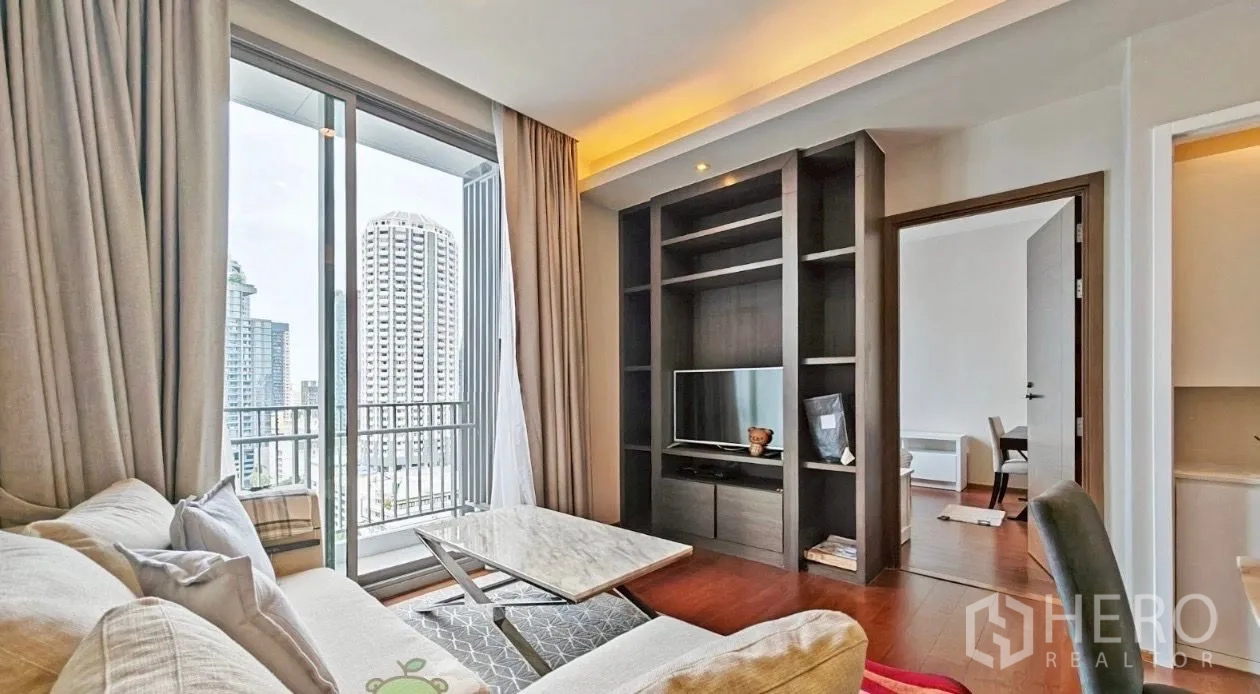 คอนโด ให้เช่าในWatthana, Bangkok - ห้องนั่งเล่นหันเข้าชั้นวางบิวท์อินและทีวี มีระเบียงและประตูทางเข้าห้องนอน