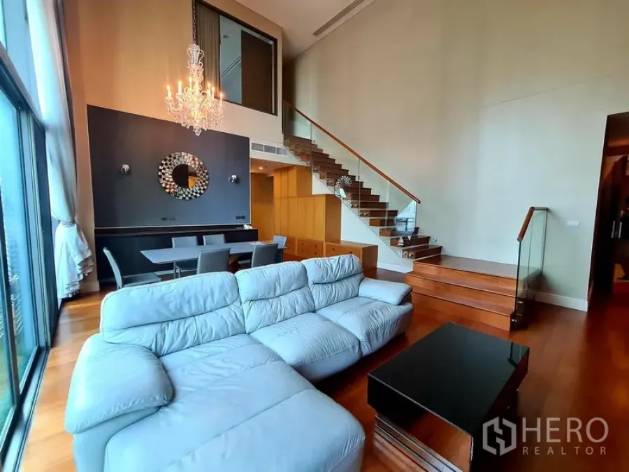 คอนโด ให้เช่าในKhlong Toei, Bangkok - โถงนั่งเล่นโอเพ่นแพลน โซฟาตัวยาว ชุดทานอาหาร และบันไดราวกระจกข้างหน้าต่างบานใหญ่