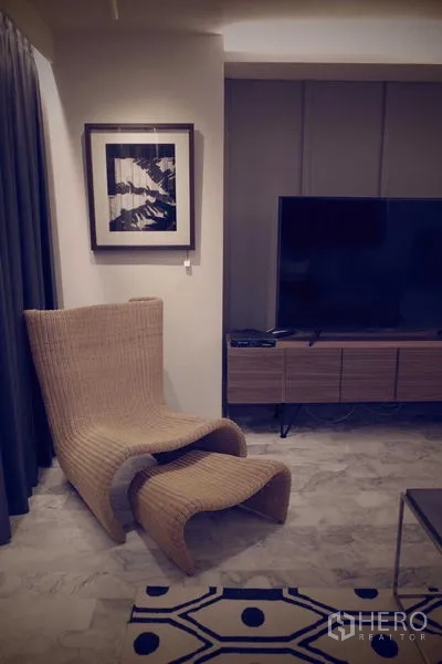 คอนโด ให้เช่าในWatthana, Bangkok - มุมดูทีวีอบอุ่น เก้าอี้หวาย ทีวีจอใหญ่ และตู้วางสื่อสมัยใหม่