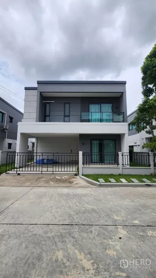 Detached House for rent in Bang Phli, Samut Prakan - Modern two-storey detached house with covered two-car carport, small lawn and gated frontage in a new community.
