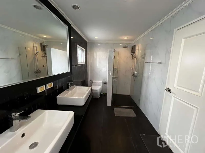 บ้าน ให้เช่าในPrawet, Bangkok - ห้องน้ำขนาดใหญ่มีอ่างล้างหน้าคู่ โถสุขภัณฑ์ และตู้กระจกอาบน้ำ.