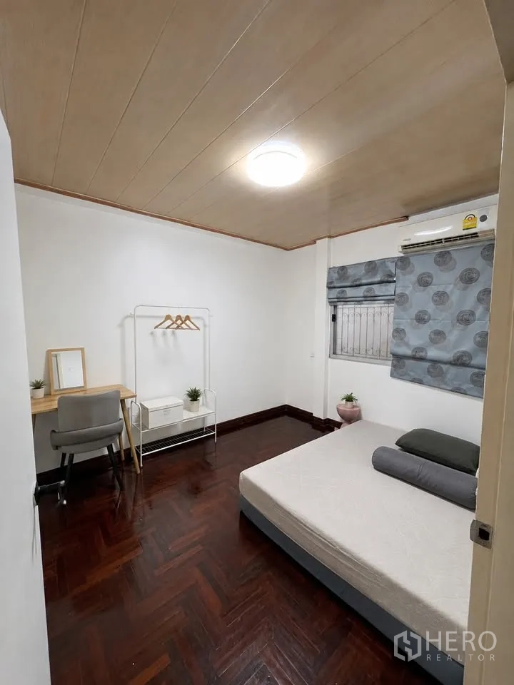 Detached House for rent in Prawet, Bangkok - Minimal room with bed, study desk, clothes rack and parquet floor.