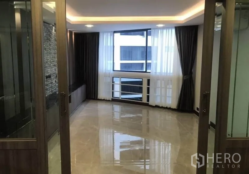 คอนโด ให้เช่าในKhlong Toei, Bangkok - พื้นที่นั่งเล่นสว่างด้วยหน้าต่างบานใหญ่ พื้นกระเบื้องเงา และประตูกระจก