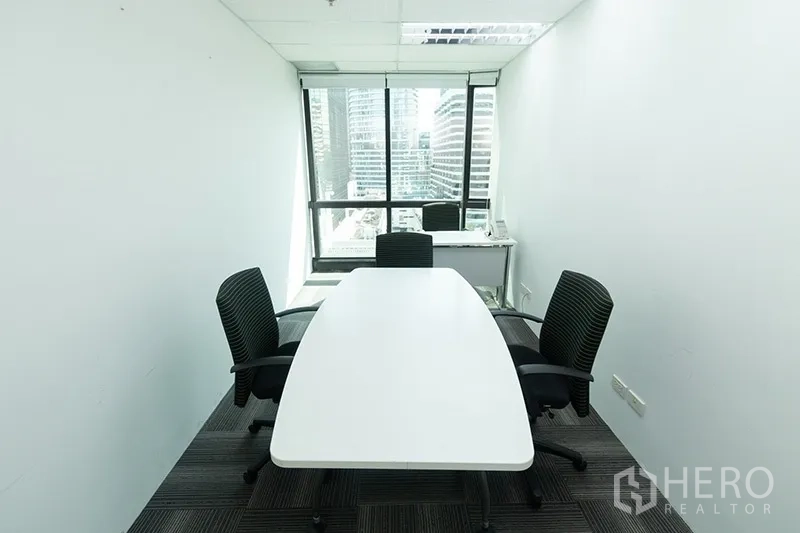 办公空间 出租 - 小型会议室，椭圆桌与三把椅子，窗外为高楼景观。